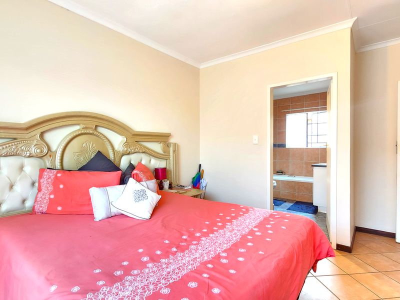 A bedroom featuring tiled flooring and cove cornicing, with direct access to an en-suite bathroom.