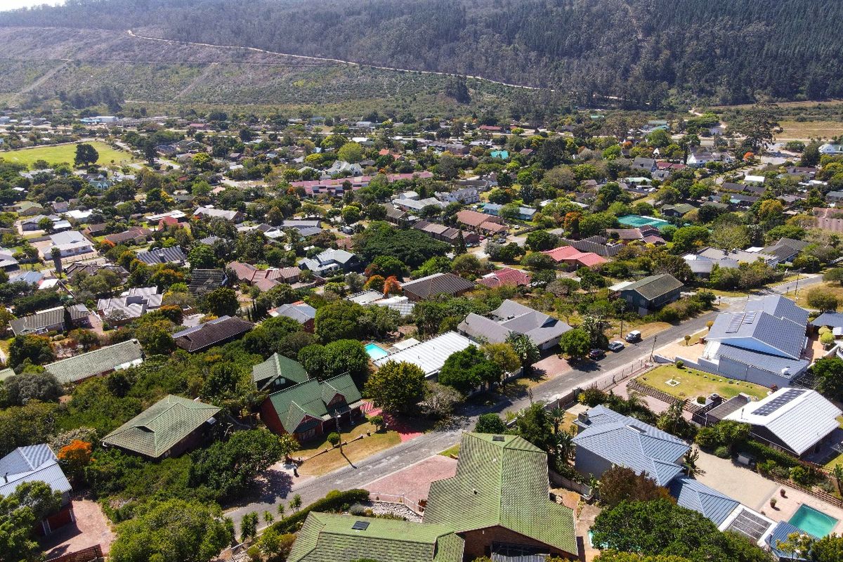 An aerial view of a residential neighborhood featuring established homes, mature trees, and surrounding landscape.