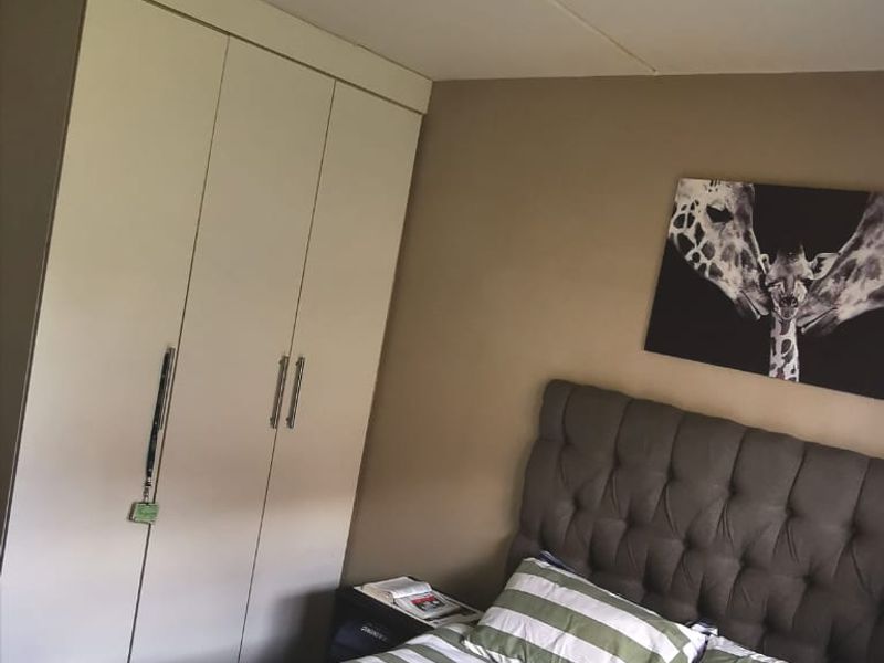 A bedroom featuring a built-in wardrobe and a flush mount ceiling light fixture.
