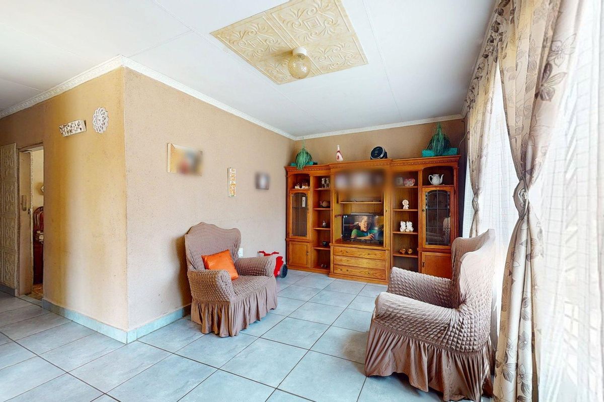 A living room featuring tiled flooring and a decorative ceiling panel, offering a functional space with potential for modern updates.