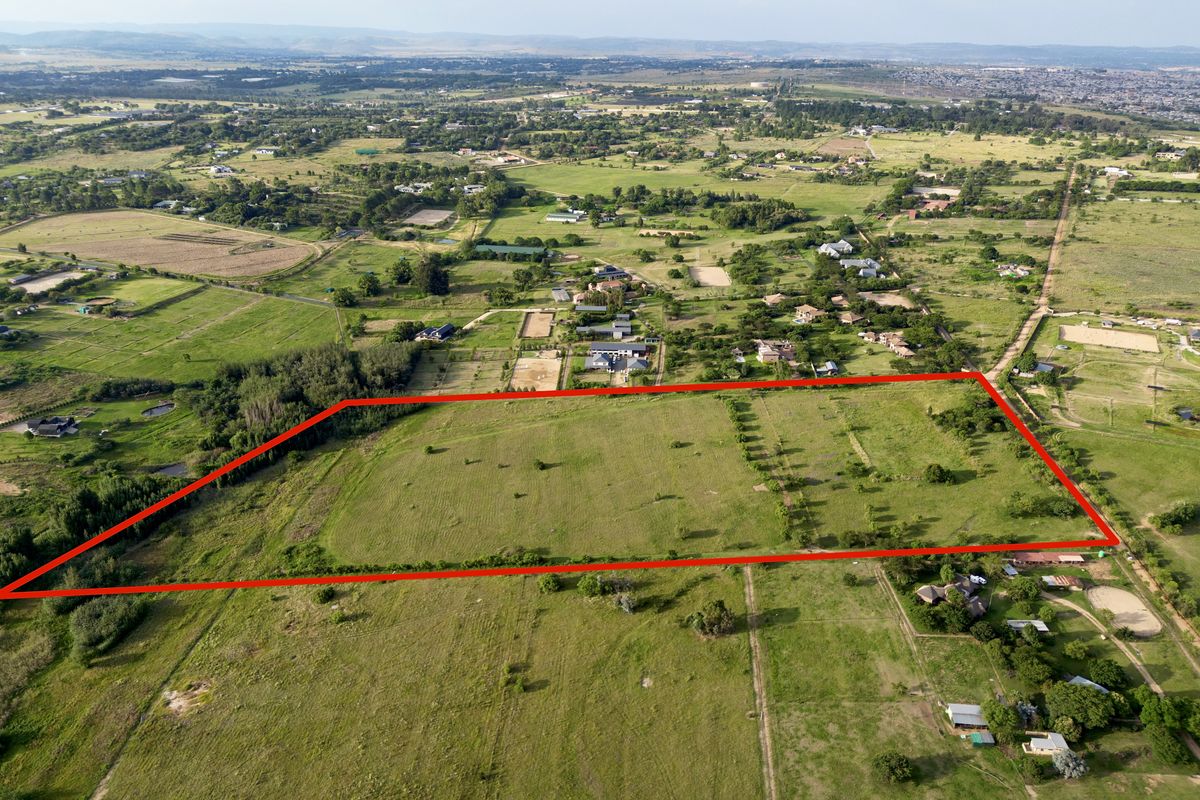 An aerial view of a large, vacant residential plot of land, highlighting the boundaries and surrounding rural landscape.