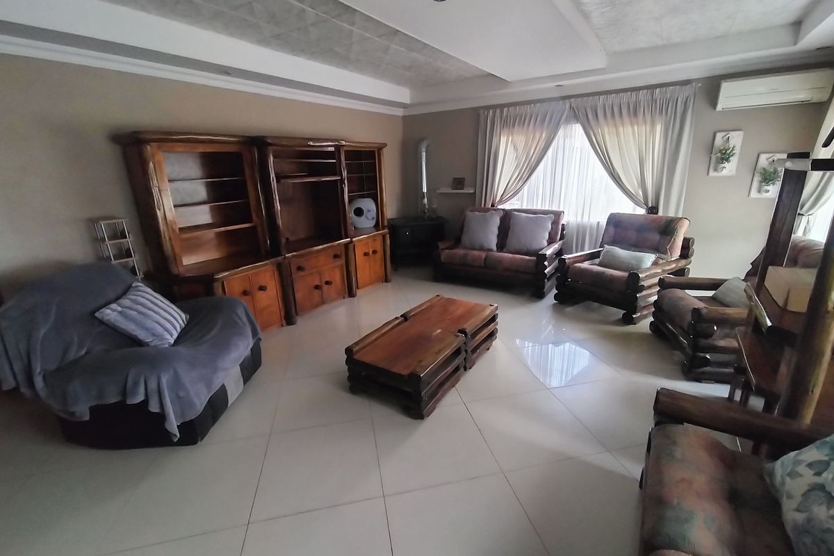Spacious living room featuring tiled flooring, a recessed ceiling with downlights, and a built-in wood burning stove.