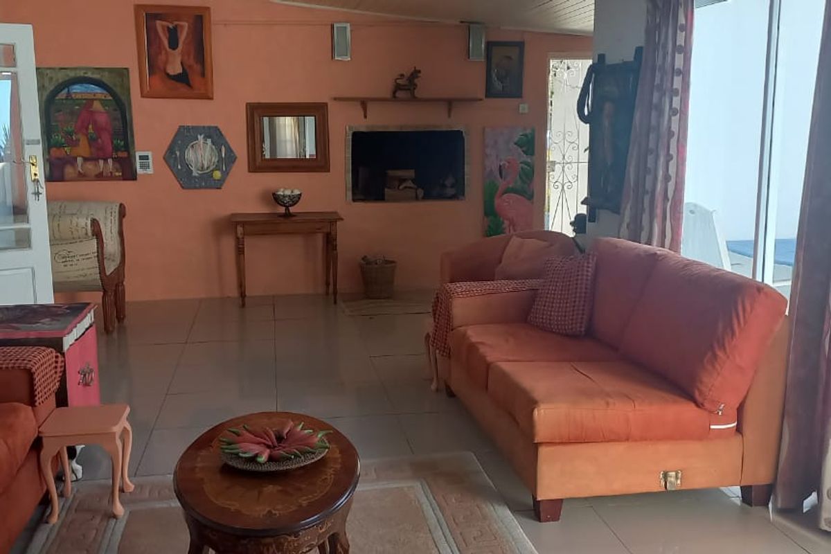 Spacious living room featuring tiled flooring, a built-in fireplace, and large sliding glass doors providing natural light and access to the exterior.