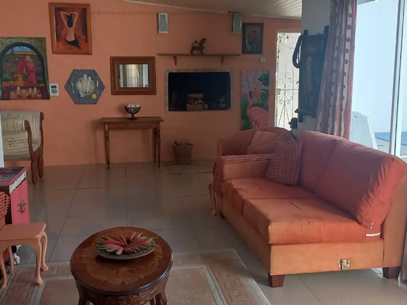 Spacious living room featuring tiled flooring, a built-in fireplace, and large sliding glass doors providing natural light and access to the exterior.