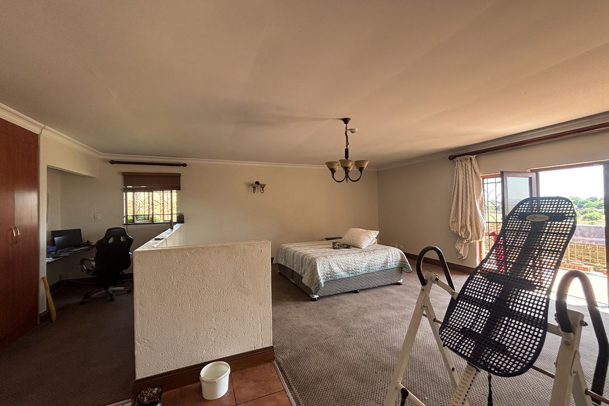 Spacious bedroom featuring a built-in wardrobe, carpeted flooring, and direct access to an outdoor balcony area.