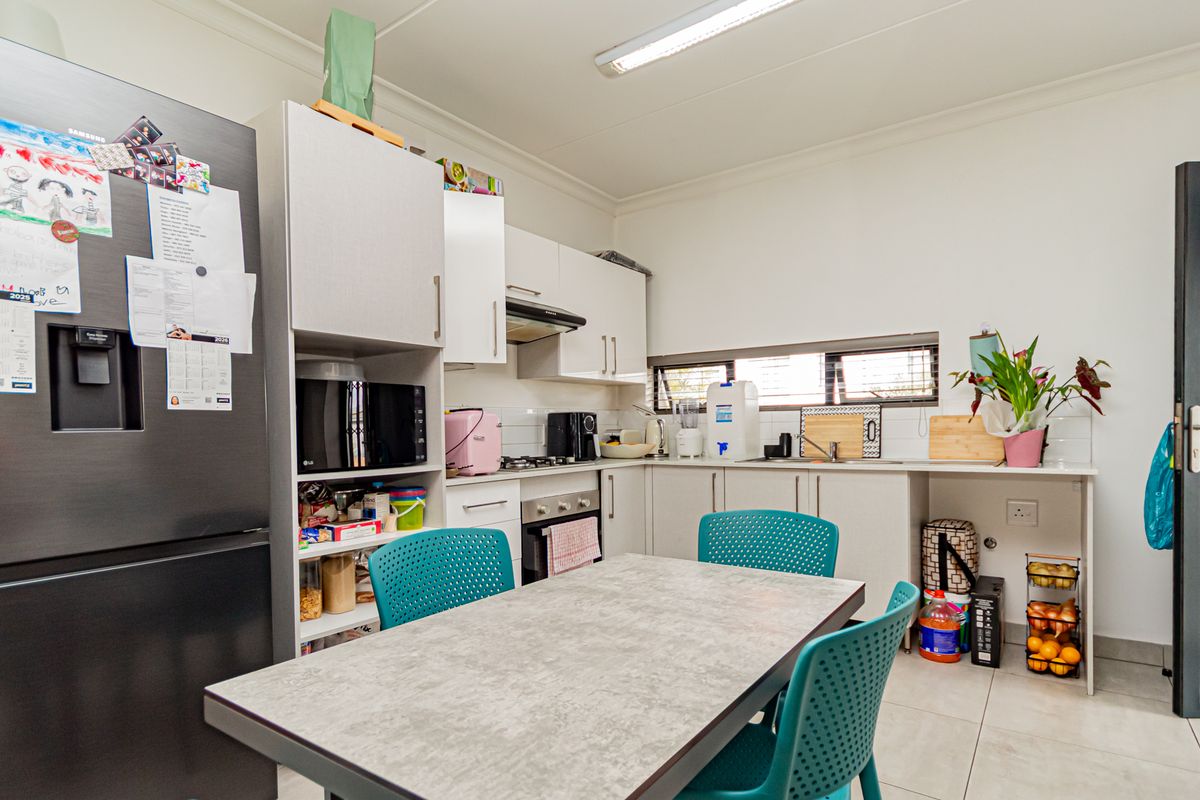 Functional kitchen featuring built-in cabinetry, integrated oven and hob, tiled backsplash, and tiled flooring, providing a practical workspace for daily meal preparation.