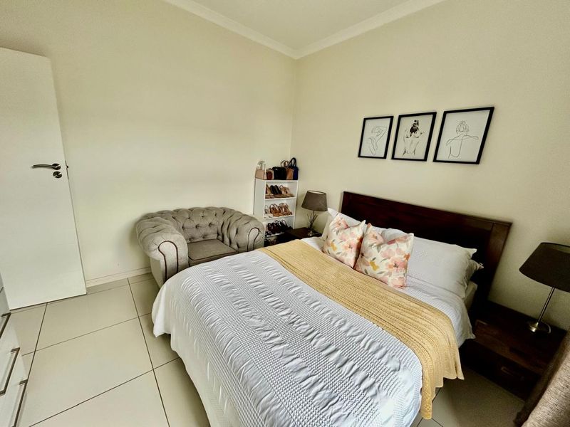 A well-maintained bedroom featuring neutral wall tones and tiled flooring, providing a clean and functional living space.