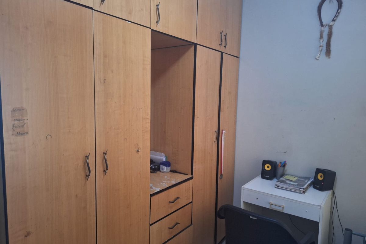 A bedroom featuring extensive floor-to-ceiling built-in wooden cabinetry with integrated shelving and drawer storage.