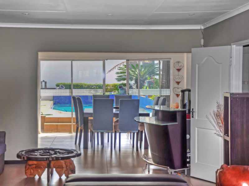 Open plan living area featuring tiled flooring and large sliding glass doors providing direct access to the outdoor pool area.