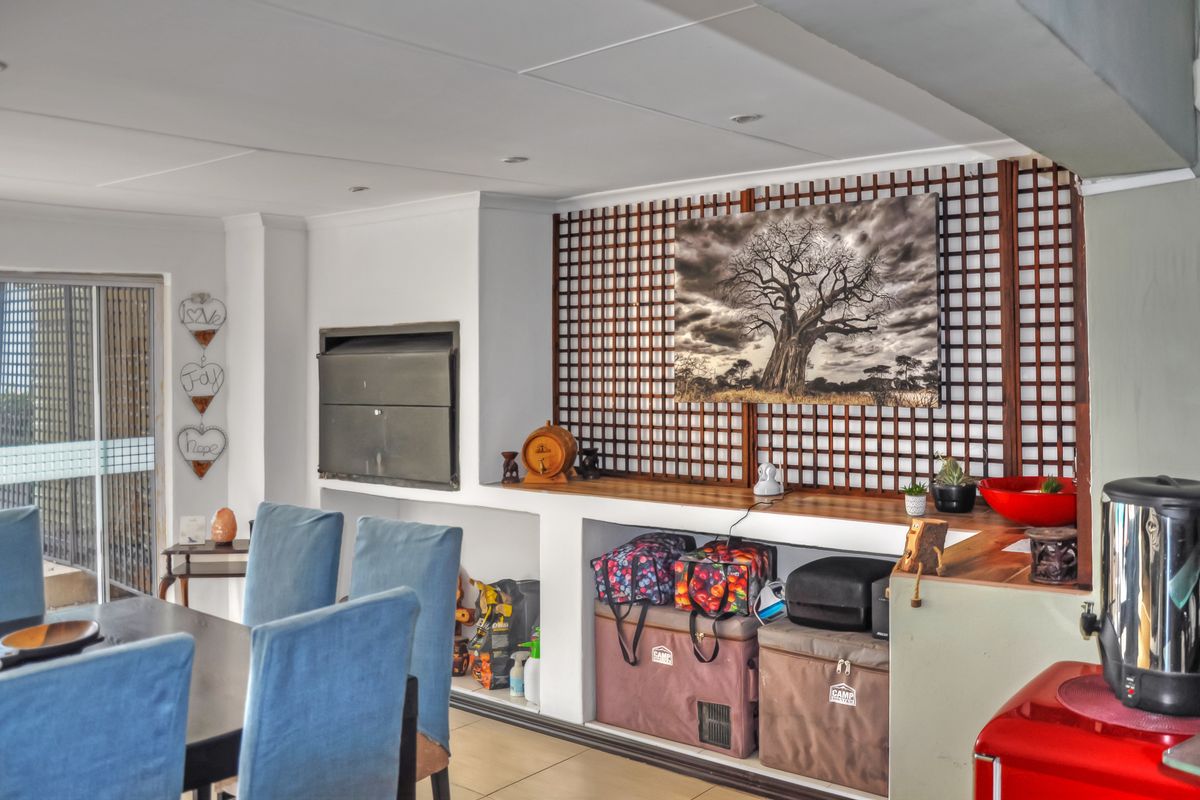 Living area featuring a built-in fireplace, decorative wooden lattice wall paneling, tiled flooring, and access to an outdoor space via sliding glass doors.