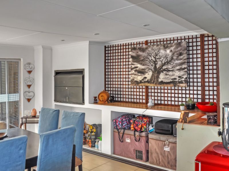 Living area featuring a built-in fireplace, decorative wooden lattice wall paneling, tiled flooring, and access to an outdoor space via sliding glass doors.