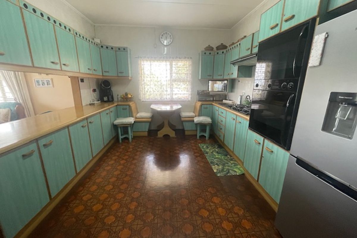 A spacious kitchen featuring extensive built-in cabinetry, a built-in oven, hob, and a cozy integrated breakfast nook area.