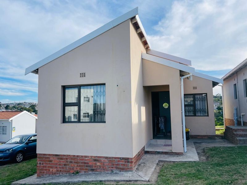 Front elevation of a single-story residential house featuring a brick plinth, pitched roof, and security-fitted windows.