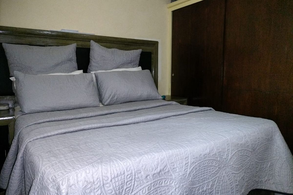 A bedroom featuring a built-in wooden wardrobe and neutral wall finishes.