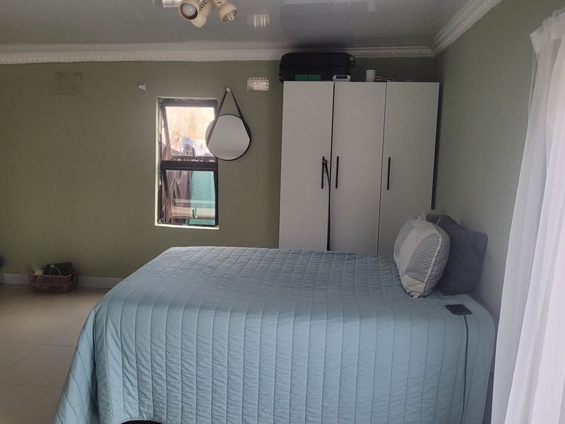 A functional bedroom featuring tiled flooring, ceiling cornicing, and a built-in wardrobe, offering a neutral base for personalization.