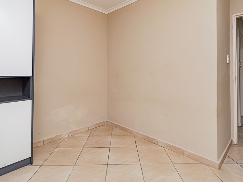 A neutral hallway space featuring ceramic floor tiles and built-in cabinetry, providing a clean and functional transition area within the home.