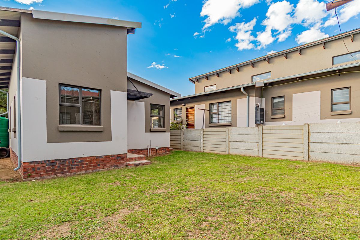Rear view of the property featuring a private garden, precast boundary wall, and rainwater harvesting infrastructure.