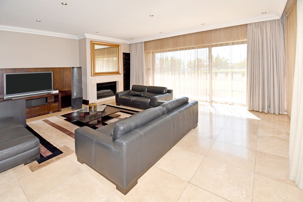 Spacious living room featuring stone tile flooring, a built-in fireplace, and large sliding glass doors that provide ample natural light.