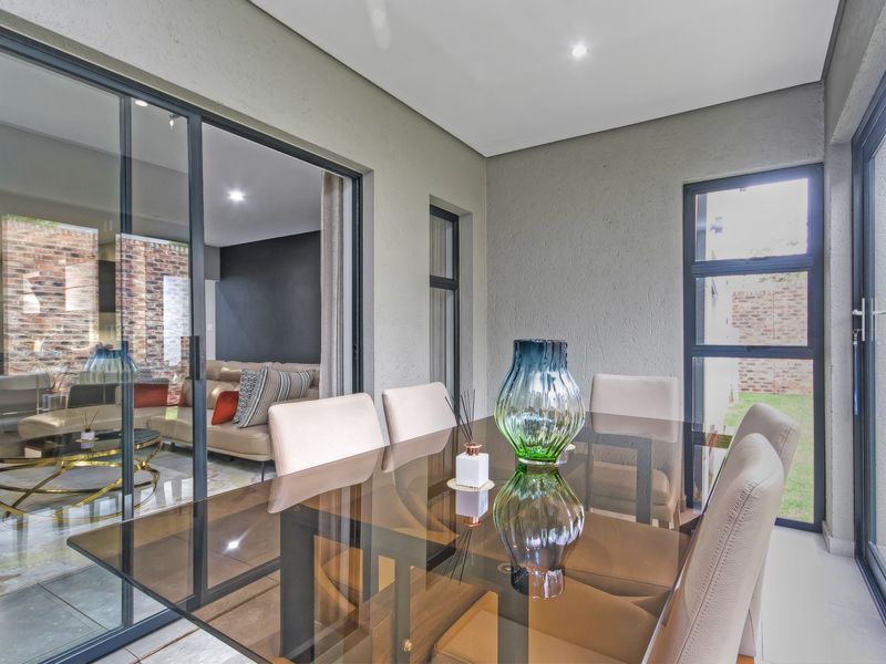 A modern, enclosed patio area featuring large sliding glass doors, tiled flooring, and recessed downlights, offering a seamless transition to the interior living space.