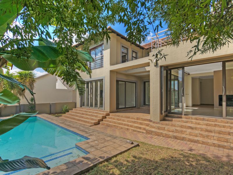 Rear view of the property featuring a swimming pool, paved patio area, and large sliding glass doors leading into the home.
