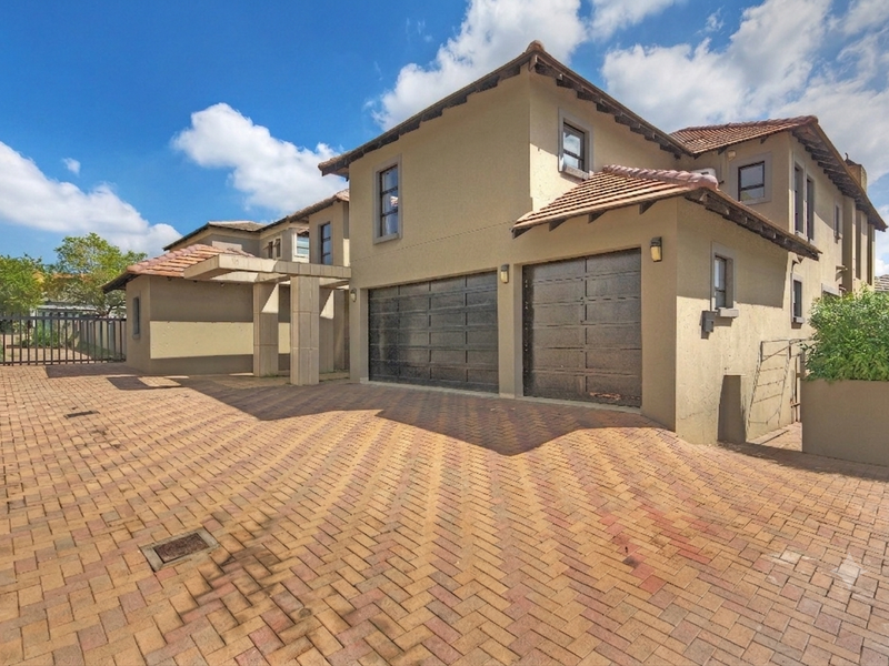 Front elevation of a double-story house featuring a paved driveway, double garage, and tiled roof architecture.