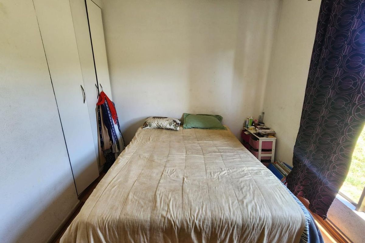 A bedroom featuring built-in cupboards and natural light, requiring cosmetic updates to refresh the space.