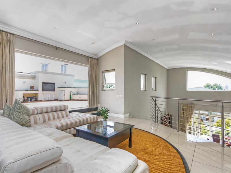 Spacious open-plan living area featuring vaulted ceilings, tiled flooring, and seamless flow to an expansive outdoor patio area.