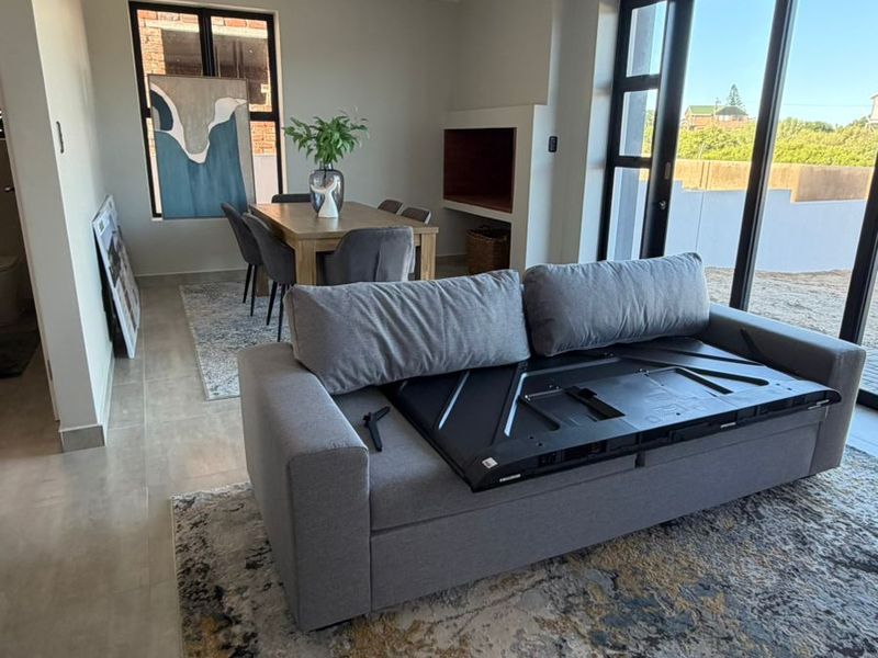 Open-plan living and dining area featuring tiled floors, recessed fireplace, and large sliding glass doors providing ample natural light and outdoor access.