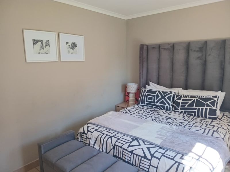 A well-maintained bedroom featuring neutral wall tones and classic cove cornicing, providing a comfortable and inviting sleeping space.