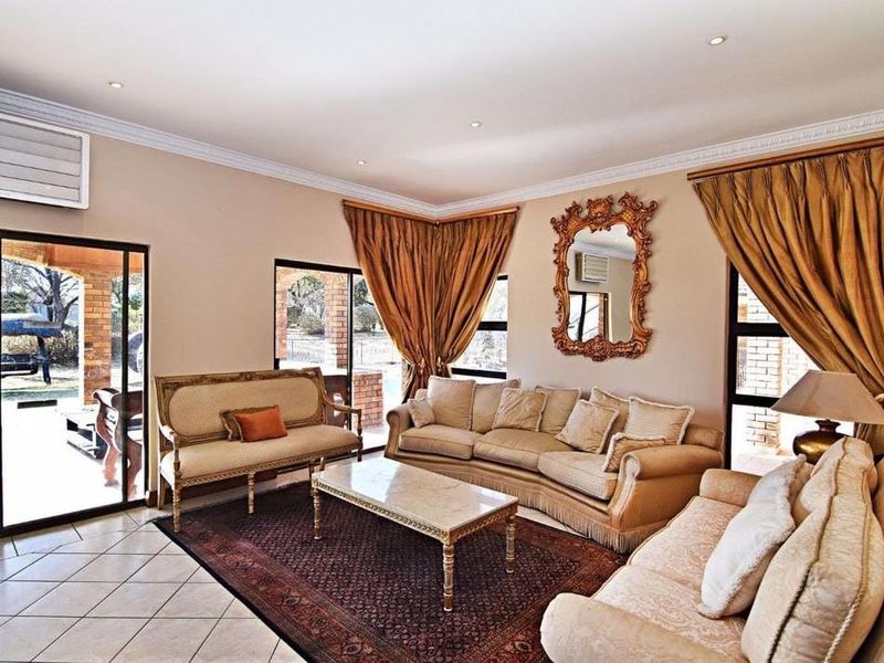 Spacious living room featuring ceramic tile flooring, crown molding, recessed lighting, and large sliding glass doors providing access to the outdoor patio area.