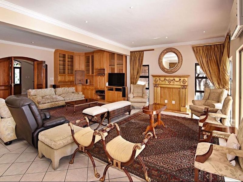 Spacious living room featuring built-in wooden cabinetry, a decorative fireplace, tiled flooring, and crown molding, offering a comfortable and traditional living space.