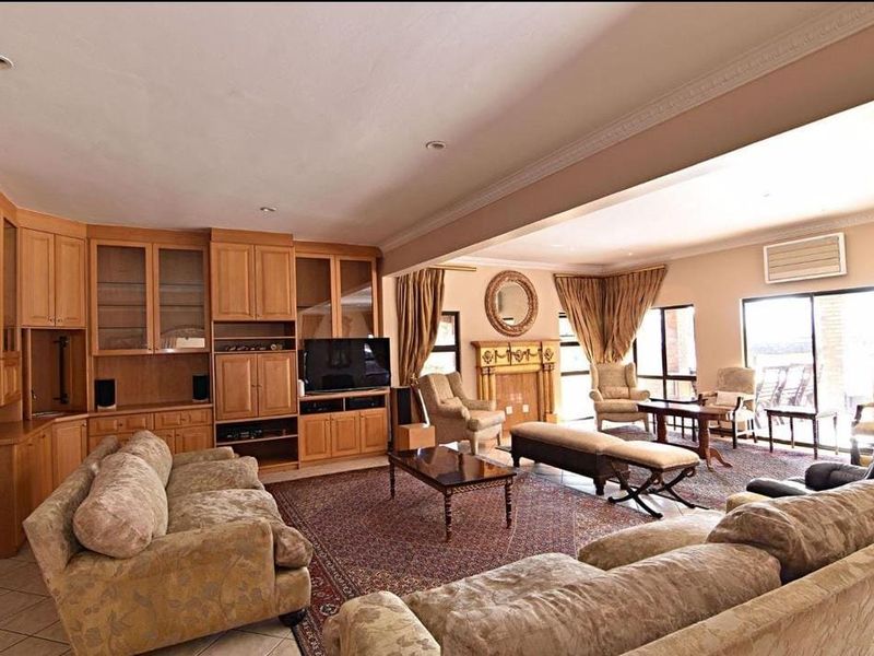 Spacious living room featuring extensive built-in cabinetry, a central fireplace, crown molding, and large sliding glass doors providing natural light.
