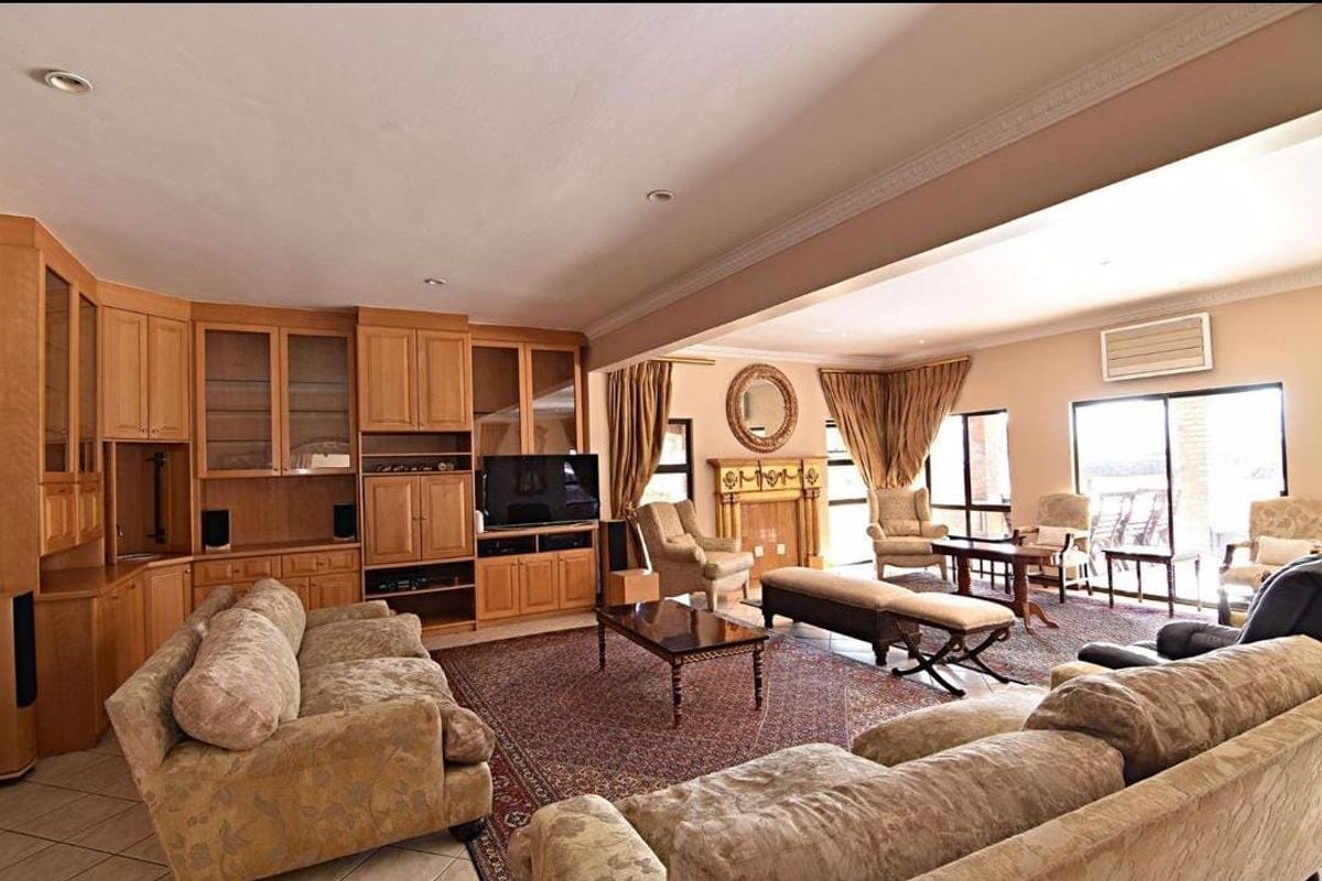 Spacious living room featuring extensive built-in cabinetry, a central fireplace, crown molding, and large sliding glass doors providing natural light.