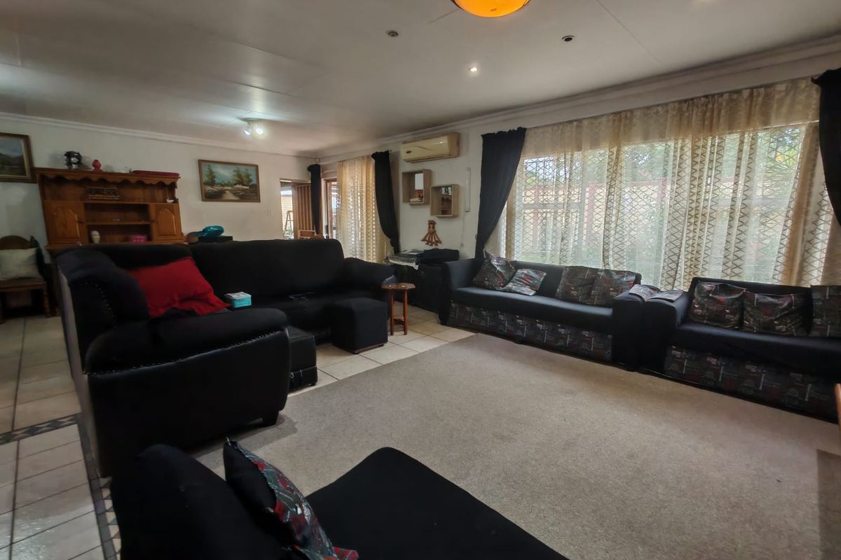 Spacious living room featuring tiled flooring, recessed ceiling lighting, and a wall-mounted air conditioning unit.