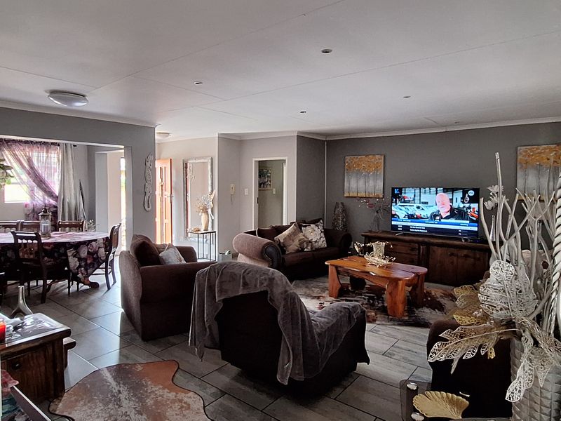 Spacious open-plan living and dining area featuring tiled flooring and recessed downlighting, offering a versatile layout for family living and entertaining.