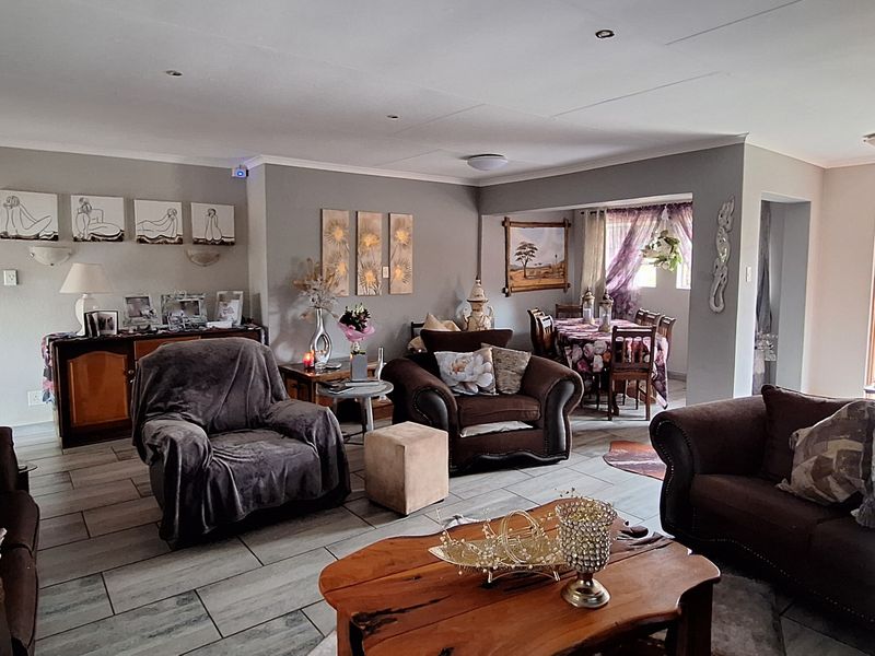Spacious open-plan living and dining area featuring tiled flooring, recessed lighting, and neutral wall finishes, creating a comfortable and connected family space.