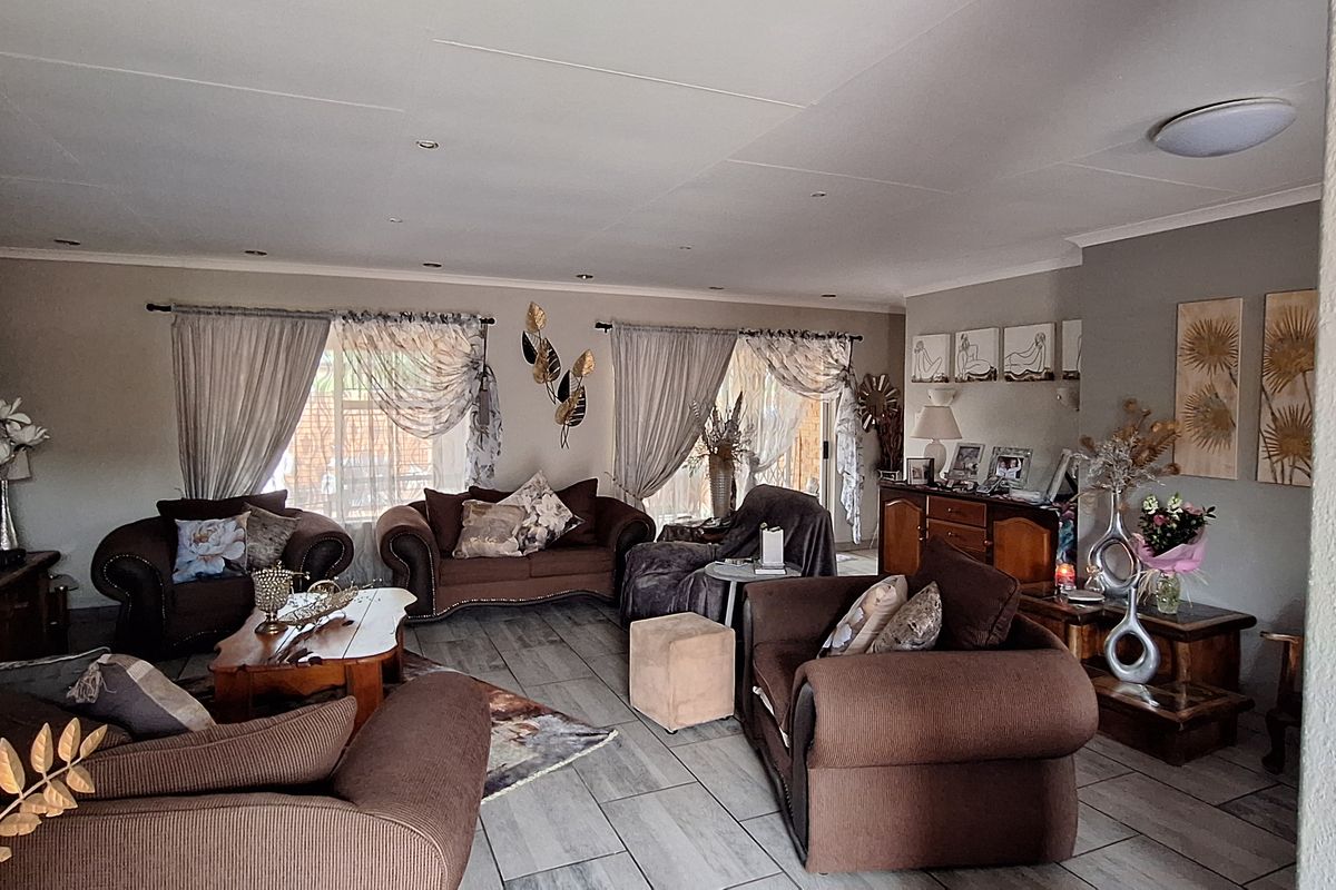 Spacious living room featuring tiled flooring, recessed downlighting, and sliding glass doors providing access to the outdoor area.
