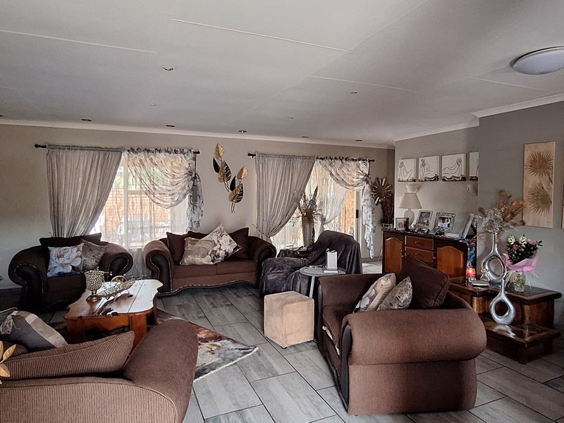Spacious living room featuring tiled flooring, recessed downlighting, and sliding glass doors providing access to the outdoor area.