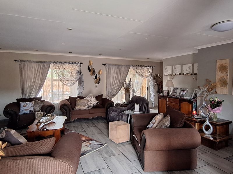 Spacious living room featuring tiled flooring, recessed downlighting, and large sliding glass doors that provide natural light and access to the outdoor area.