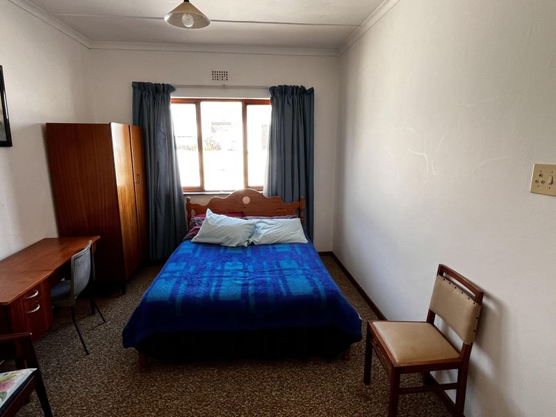 A functional bedroom featuring carpet flooring and a window with natural light, offering a blank canvas for potential cosmetic updates and modernization.