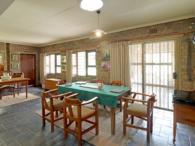 Spacious dining area featuring exposed brick walls, slate tile flooring, and direct access to the patio through a sliding glass door.