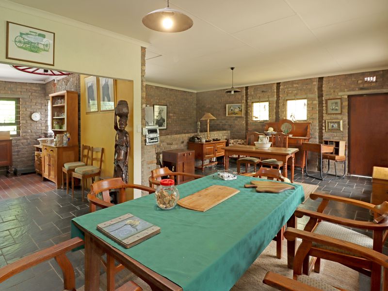 Spacious open-plan living and dining area featuring rustic exposed brick walls and durable slate tile flooring throughout.