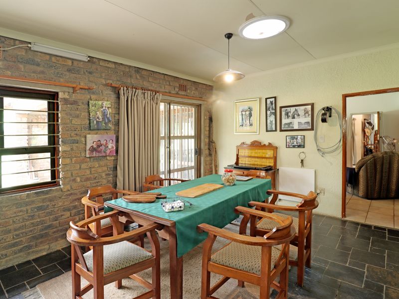 Dining room featuring exposed brick walls, slate tile flooring, and direct access to the outdoor area through a sliding glass door.