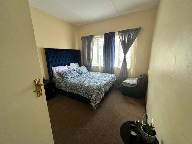 A standard bedroom featuring carpeted flooring and window curtain rails, offering a neutral base for personalization.