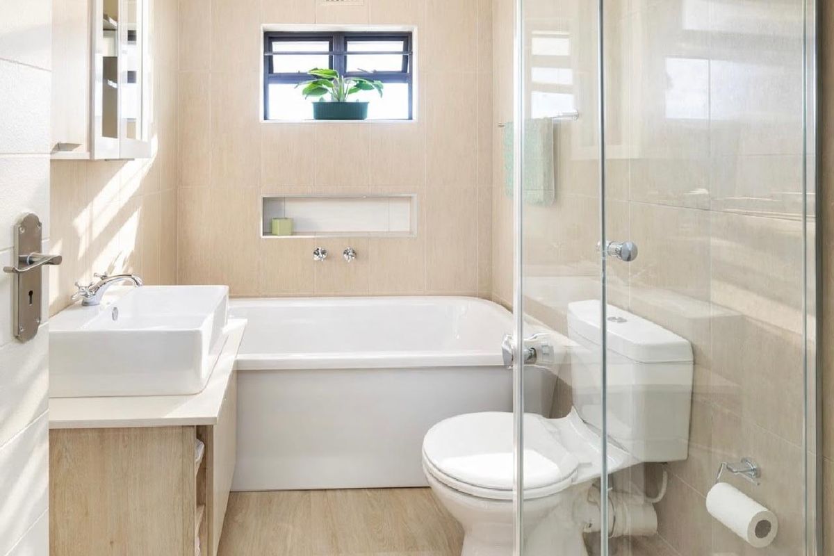 Modern bathroom featuring a built-in bathtub, separate glass-enclosed shower, countertop basin, and neutral tiled finishes throughout.