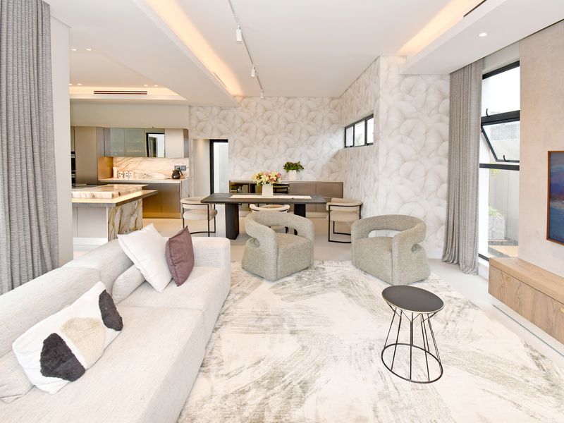 Modern open-plan living and dining area featuring high-end finishes, recessed lighting, and a sleek kitchen with marble island and integrated cabinetry.