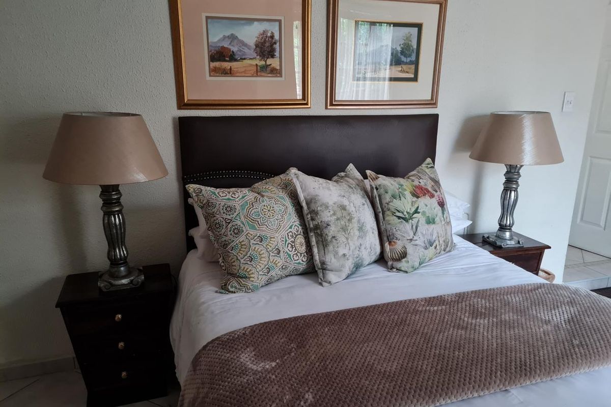 A well-maintained bedroom featuring a neutral color palette and tiled flooring, providing a comfortable and functional sleeping space.