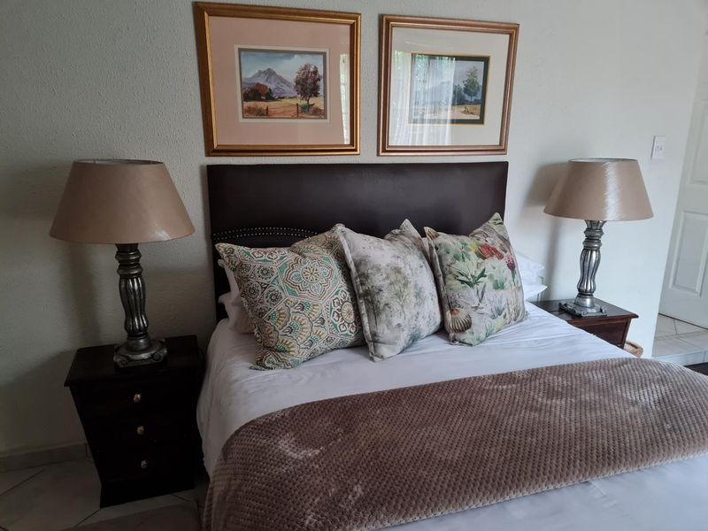 A well-maintained bedroom featuring a neutral color palette and tiled flooring, providing a comfortable and functional sleeping space.