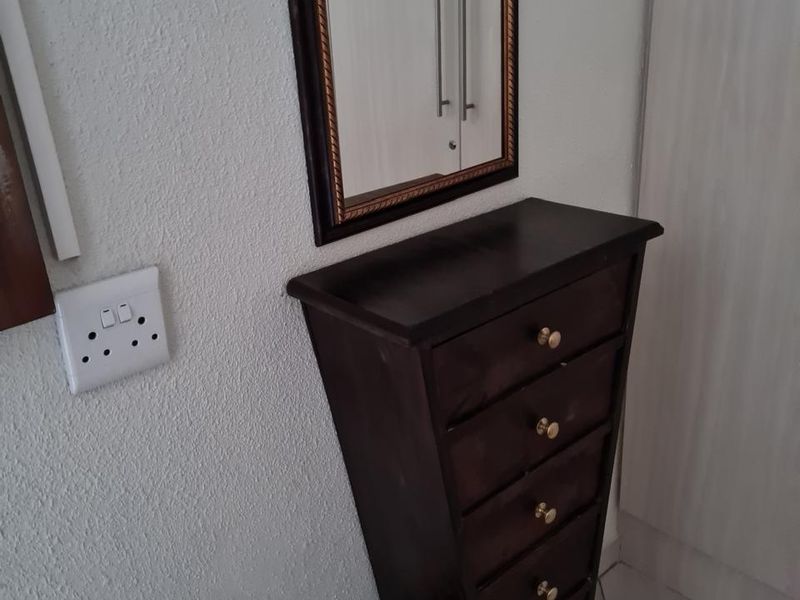 A view of a hallway area featuring tiled flooring and a wall-mounted electrical socket.