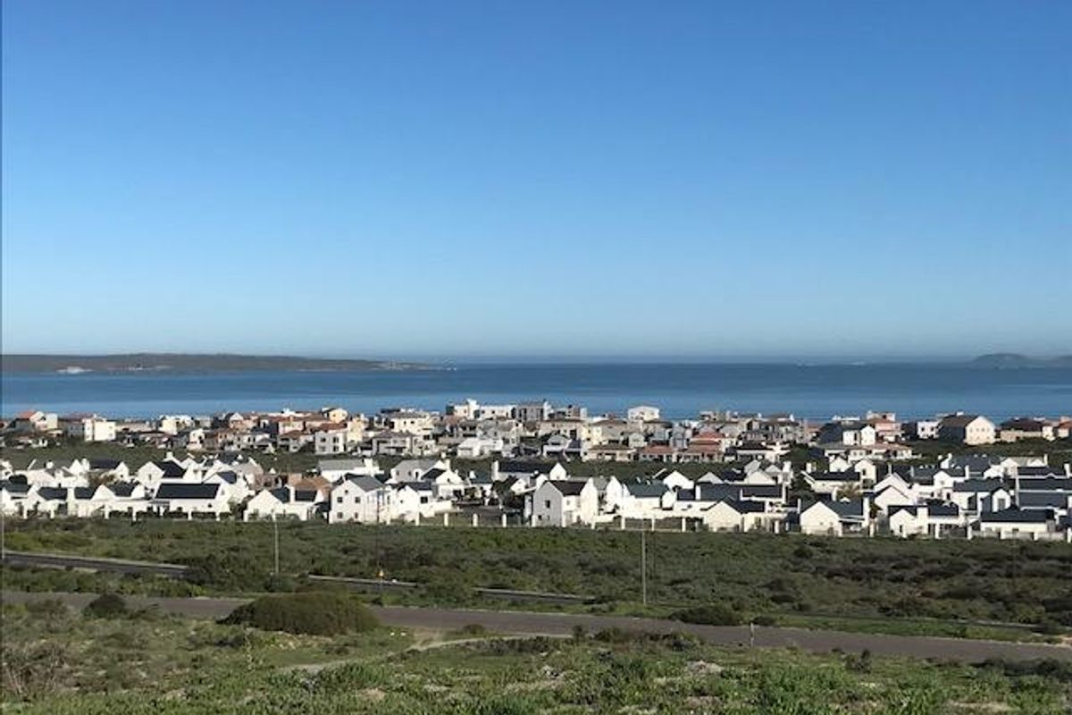 A scenic elevated view overlooking a coastal residential neighborhood and the ocean horizon.